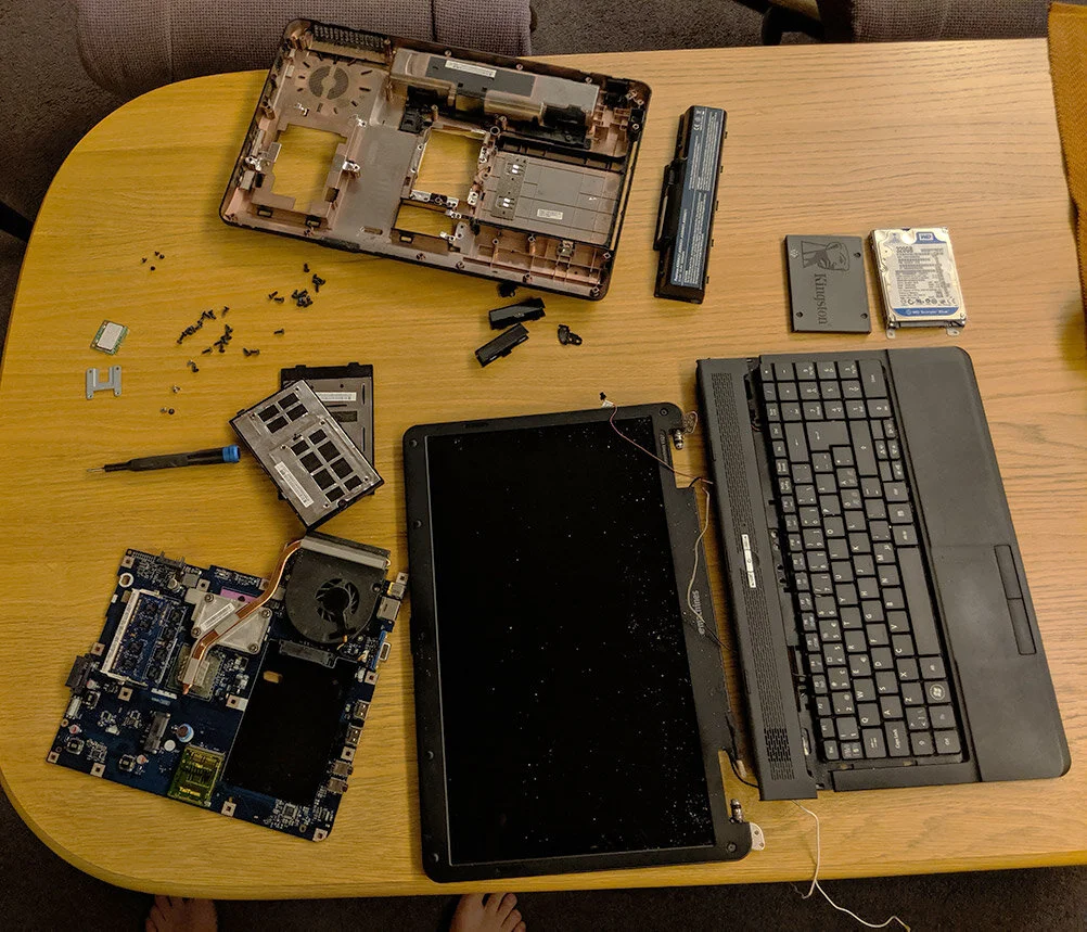 Eldre laptop demontert før rens og service