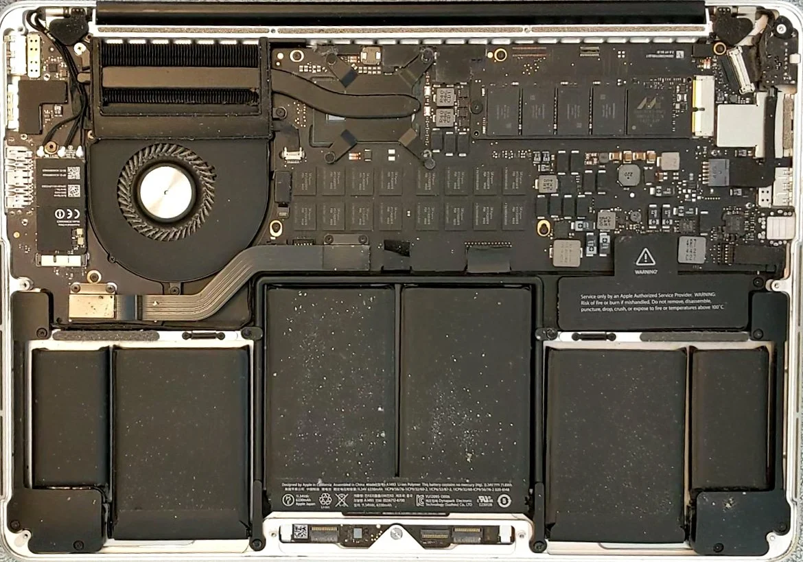MacBook Pro åpnet med batteriet synlig for kapasitetsvurdering